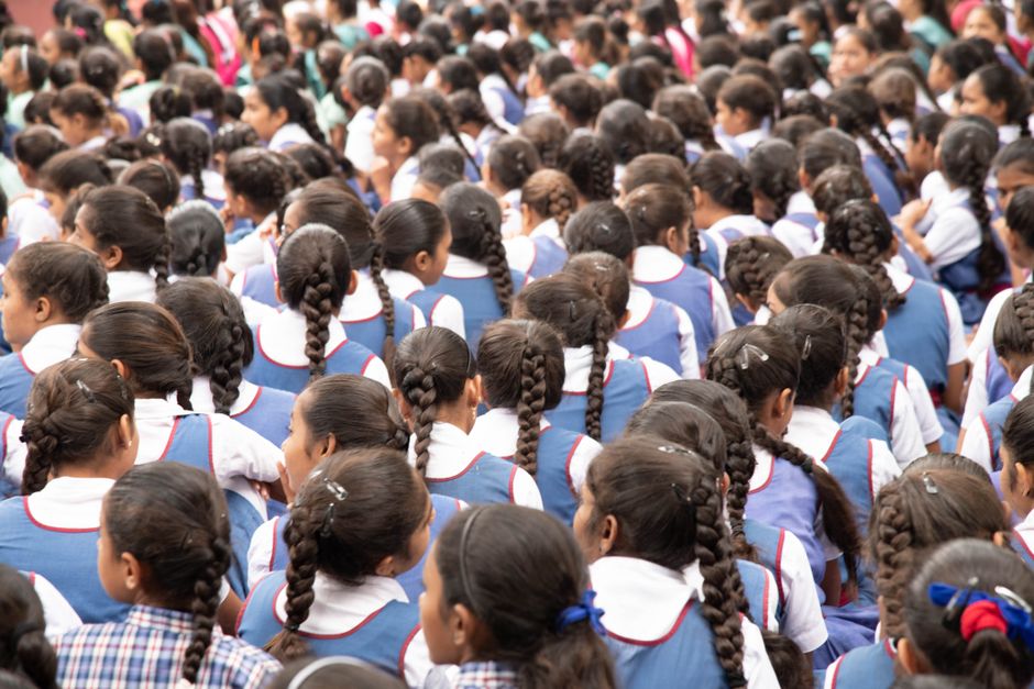 Students in uniform seated in rows at morning assembly